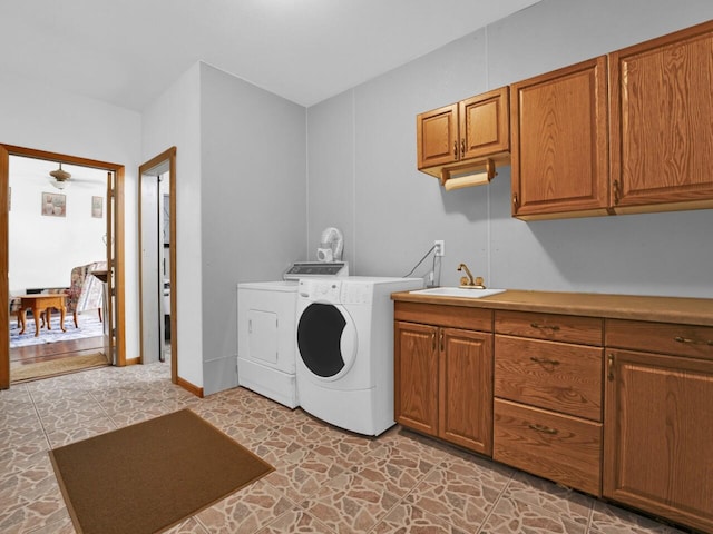 laundry area featuring sink, cabinets, and washing machine and clothes dryer