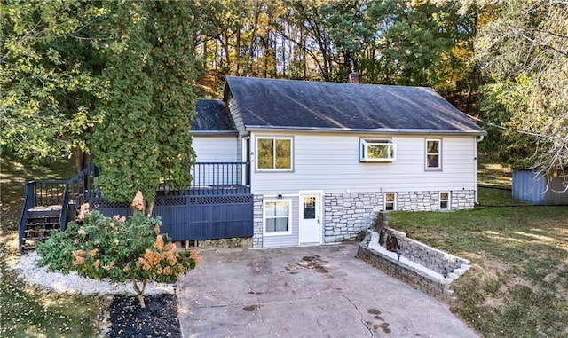 view of front of property with a deck and a front lawn