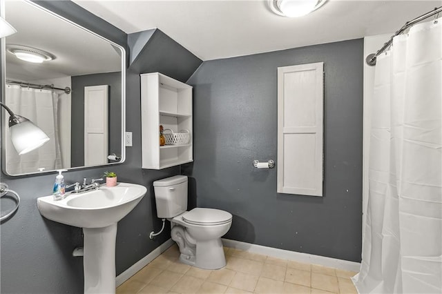 bathroom featuring toilet and tile patterned flooring