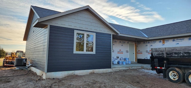 property exterior at dusk featuring central air condition unit