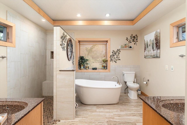 full bathroom featuring toilet, vanity, tile walls, and separate shower and tub