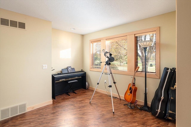 misc room featuring a textured ceiling and dark hardwood / wood-style flooring