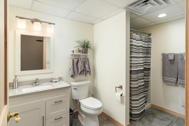 bathroom with vanity, a paneled ceiling, toilet, and tile patterned floors