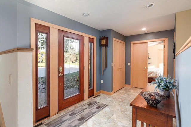 foyer entrance with a textured ceiling