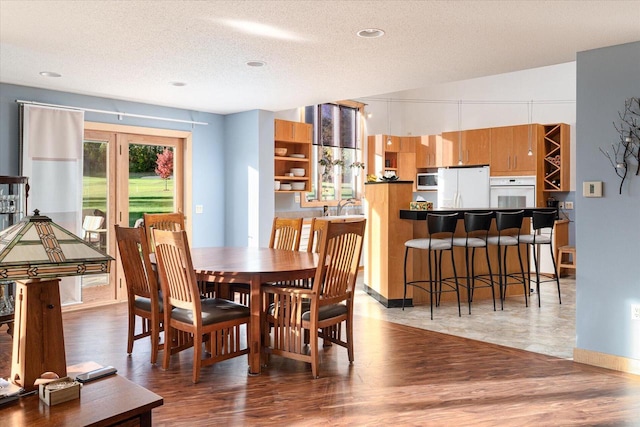 dining room with a textured ceiling and wood-type flooring