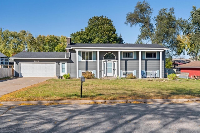 raised ranch with a garage and a front lawn