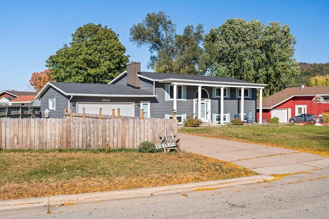 raised ranch featuring a front lawn and a garage