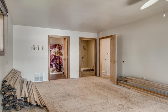 unfurnished bedroom featuring carpet, ceiling fan, connected bathroom, a closet, and a walk in closet