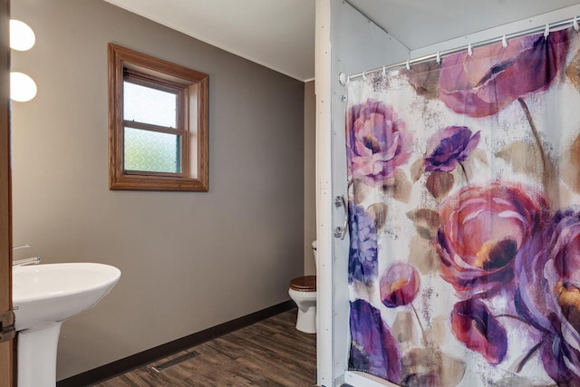 bathroom featuring toilet, sink, a shower with shower curtain, and hardwood / wood-style floors