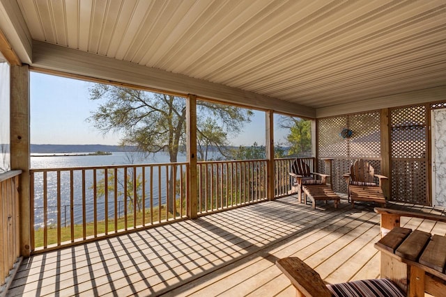 unfurnished sunroom featuring a water view