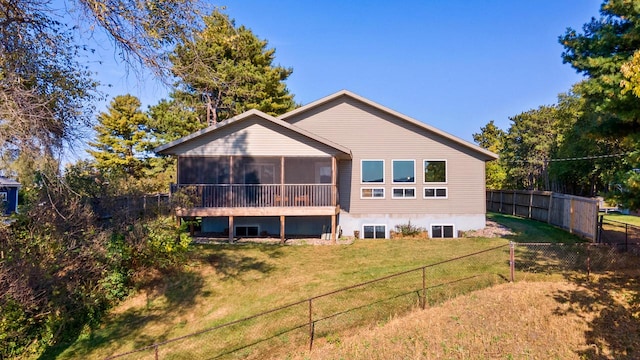 rear view of property with a yard and a sunroom