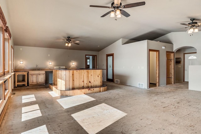 kitchen with sink, light brown cabinetry, and lofted ceiling