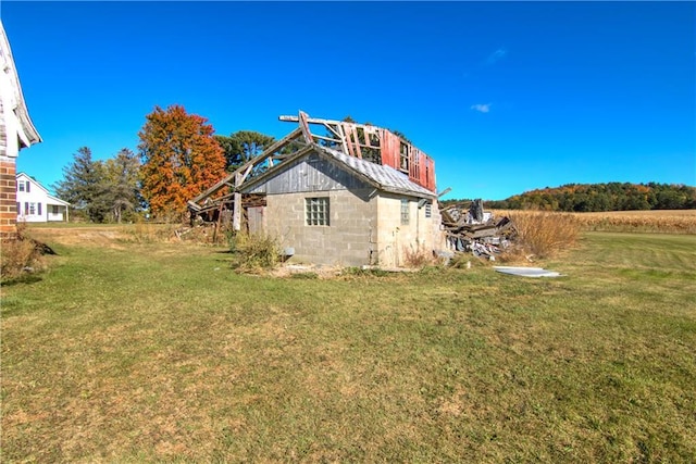 back of property with concrete block siding and a yard