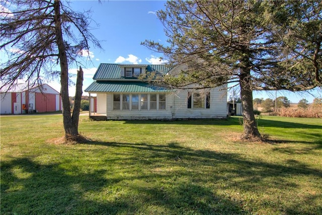 view of front of home with metal roof and a front yard