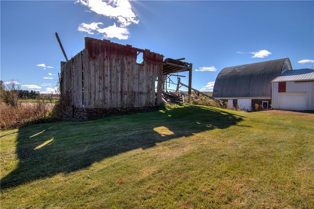 view of yard with a detached garage and an outbuilding