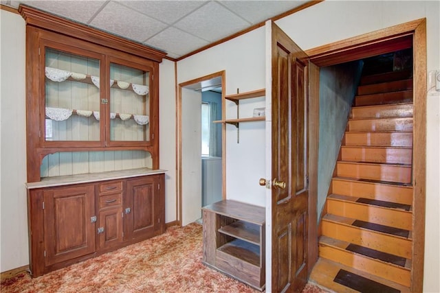 hallway featuring light carpet, stairway, and a drop ceiling