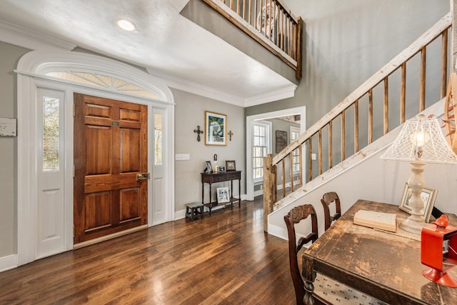 foyer entrance featuring ornamental molding and dark wood-type flooring