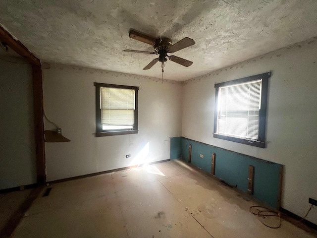 spare room featuring a healthy amount of sunlight and ceiling fan