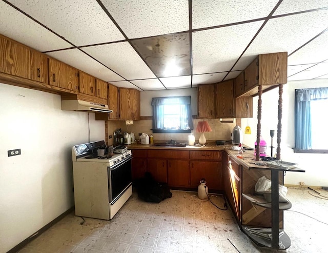 kitchen with a paneled ceiling, gas range gas stove, and sink