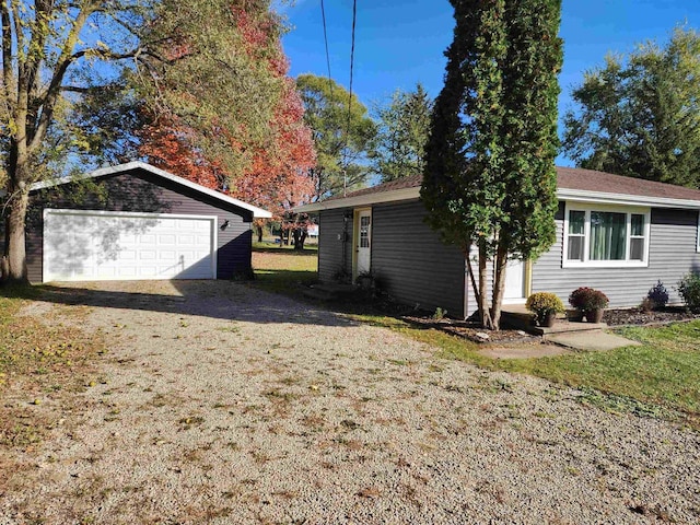 view of side of property with a lawn, a garage, and an outdoor structure