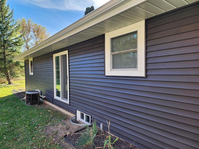 view of home's exterior featuring cooling unit and a lawn