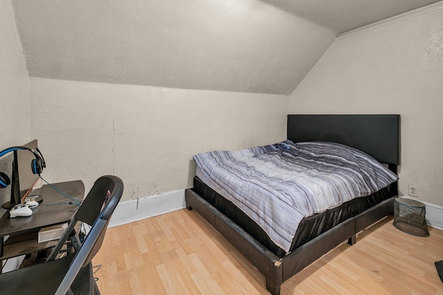 bedroom featuring lofted ceiling and hardwood / wood-style flooring