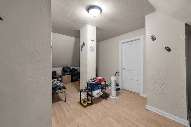 3221 N 38th St, Milwaukee, WI 53216 - additional living space featuring light wood-style floors, a textured wall, and a textured ceiling