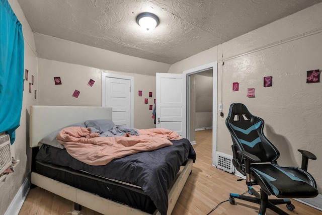 bedroom featuring light hardwood / wood-style flooring and a textured ceiling