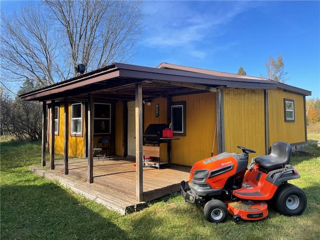 rear view of property featuring a deck and a lawn