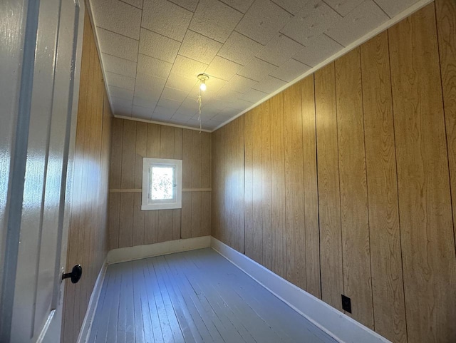 empty room with hardwood / wood-style floors and wooden walls