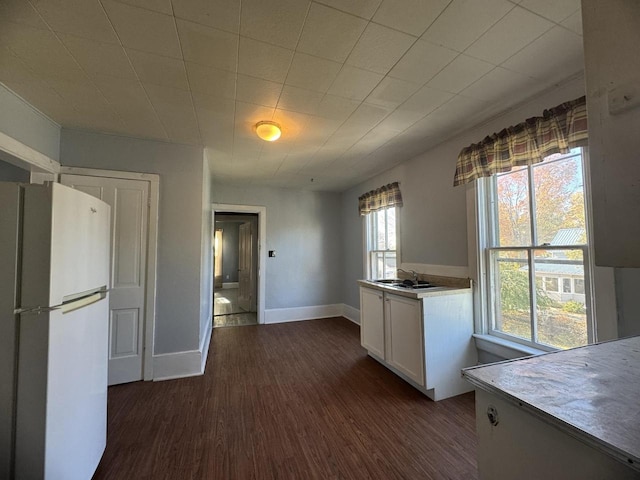 kitchen with white cabinets, dark wood-type flooring, and white refrigerator