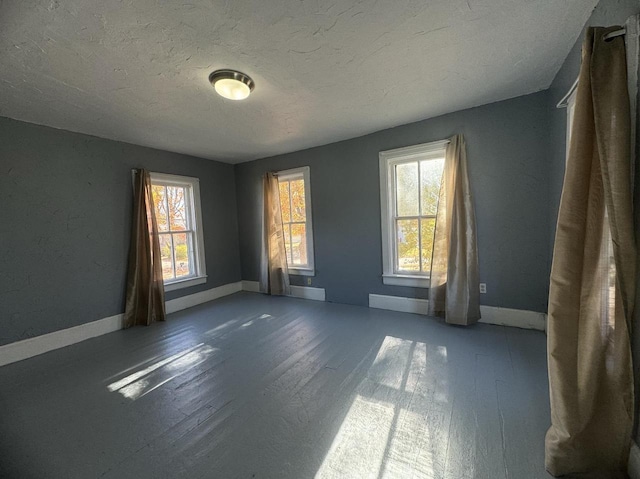 unfurnished room featuring hardwood / wood-style floors and plenty of natural light