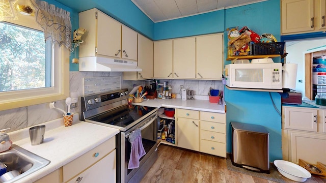 kitchen with light hardwood / wood-style floors, tasteful backsplash, stainless steel electric range, and sink