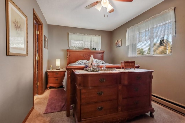 carpeted bedroom featuring ceiling fan and baseboard heating