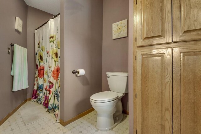 26314 276th St, Holcombe, WI 54745 - full bathroom with toilet, a shower with curtain, tile patterned floors, and baseboards