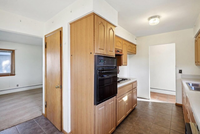 kitchen featuring light brown cabinetry, stainless steel gas cooktop, black oven, and dark tile patterned flooring