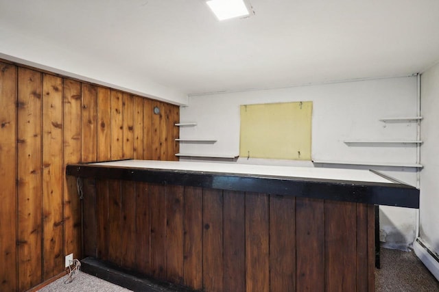 bar featuring wood walls, a baseboard heating unit, and dark colored carpet