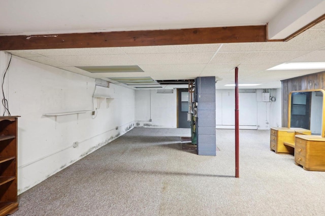 basement featuring carpet flooring, a drop ceiling, and a baseboard heating unit