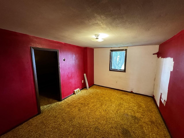 carpeted spare room featuring a textured ceiling