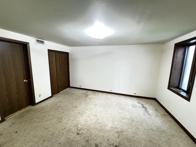 unfurnished bedroom with light colored carpet and vaulted ceiling