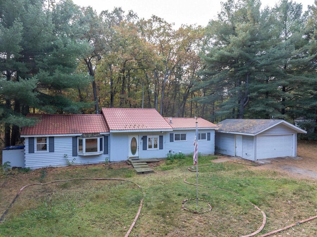 ranch-style home with a front yard, an outbuilding, and a garage