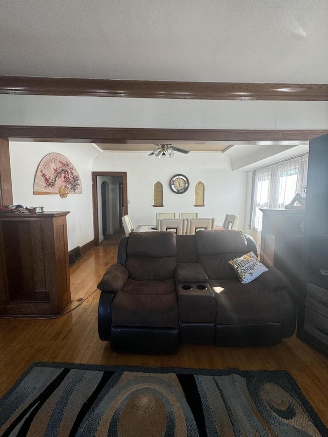 living room featuring a textured ceiling, wood-type flooring, and ceiling fan