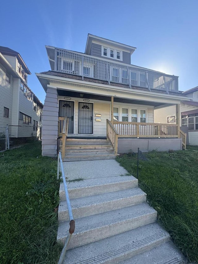view of front of property featuring a porch, a balcony, and fence