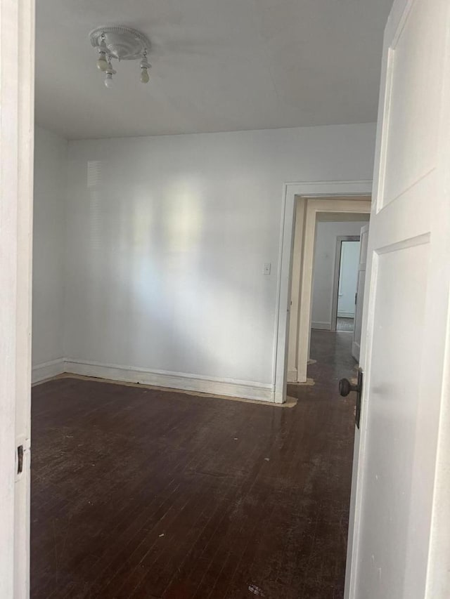 empty room featuring baseboards and hardwood / wood-style flooring