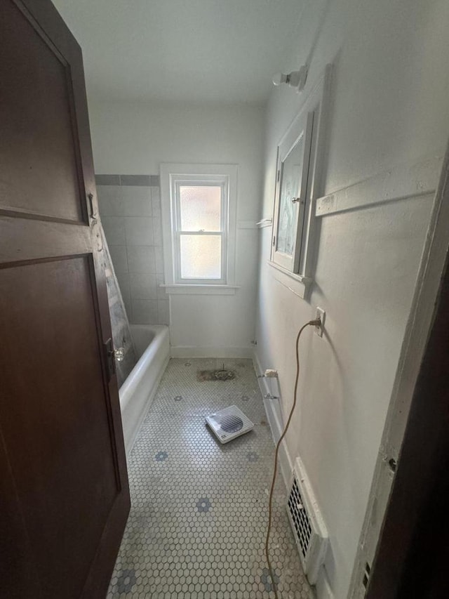 bathroom with tile patterned flooring, visible vents, baseboards, a bathtub, and walk in shower