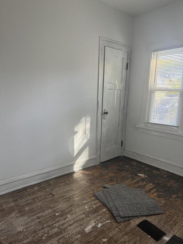 interior space featuring dark wood-type flooring and baseboards