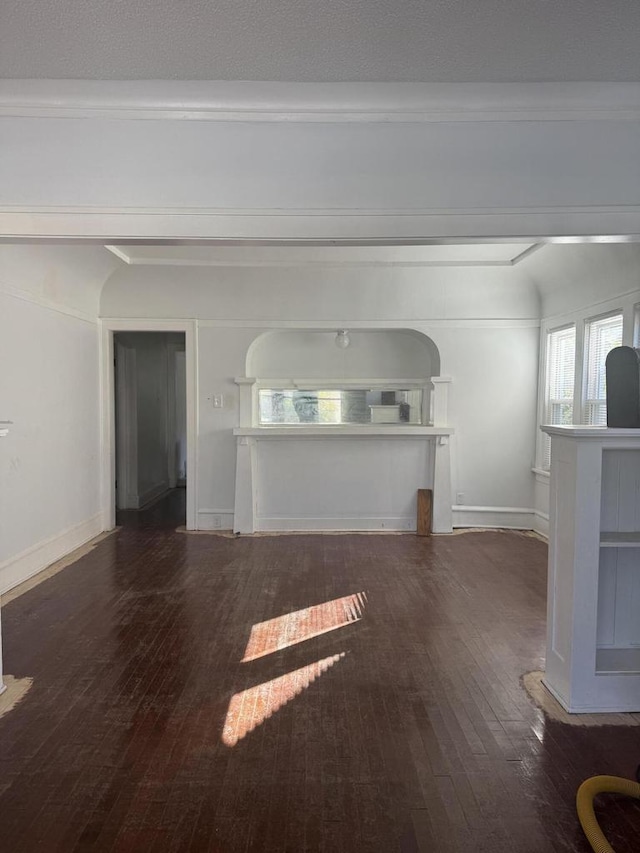 unfurnished living room with ornamental molding and dark wood-type flooring