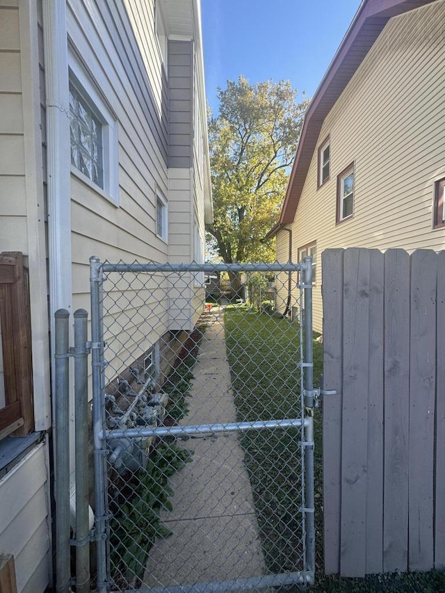 view of side of property featuring fence and a gate