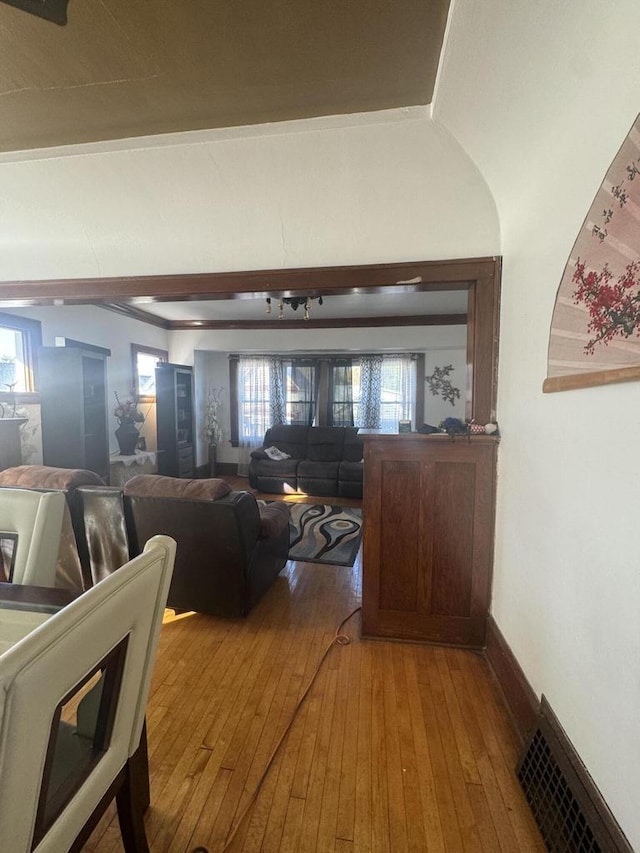living area featuring baseboards, hardwood / wood-style flooring, and visible vents