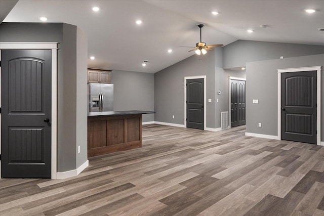 kitchen featuring hardwood / wood-style floors, lofted ceiling, stainless steel fridge, and ceiling fan